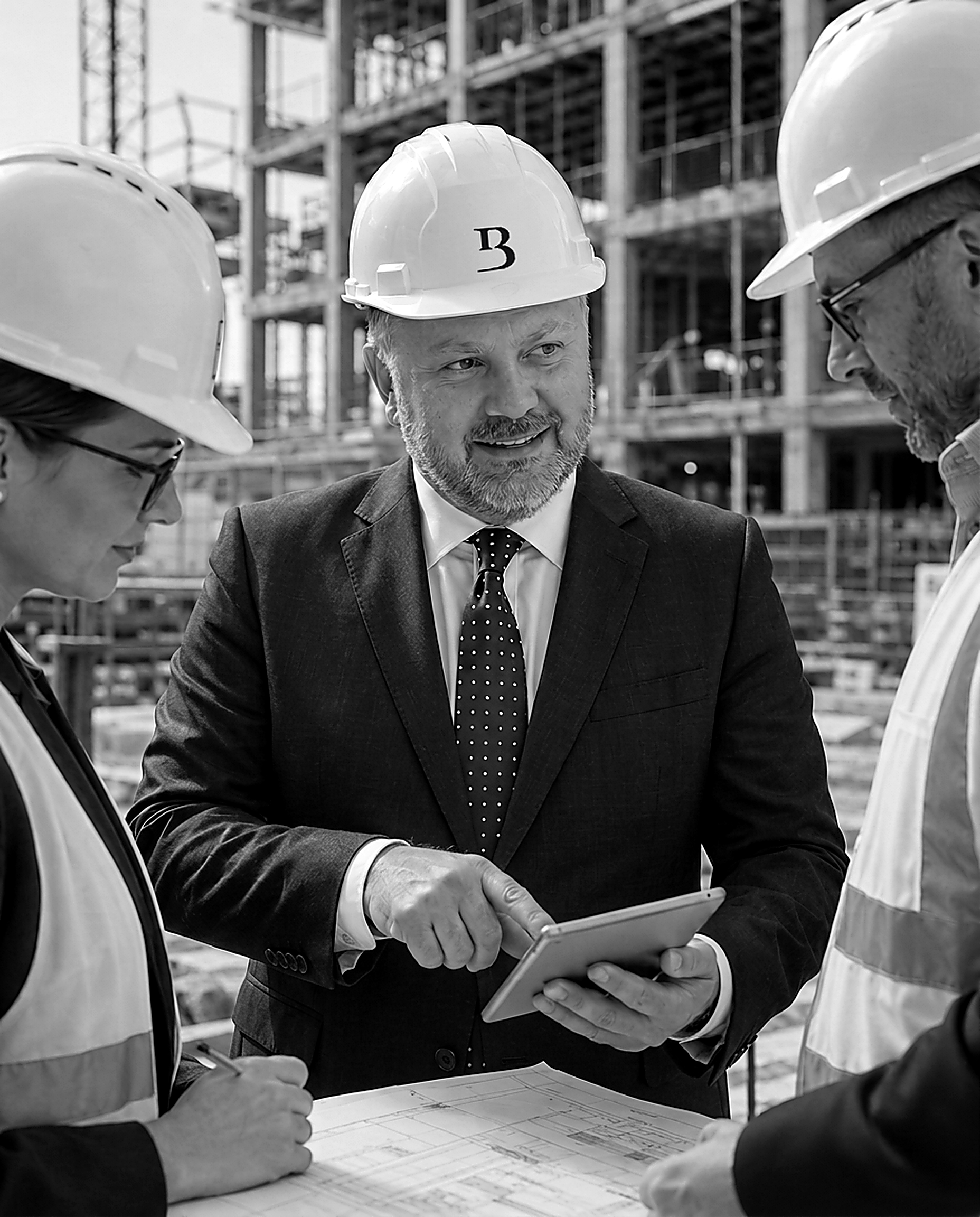 Jason Sharman reviewing a development project with two colleagues on site
